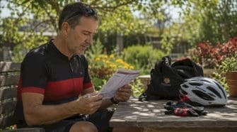 Man reviewing cycling event fee document outdoors