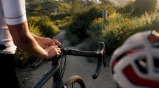 Cyclist adjusting bike computer on handlebars